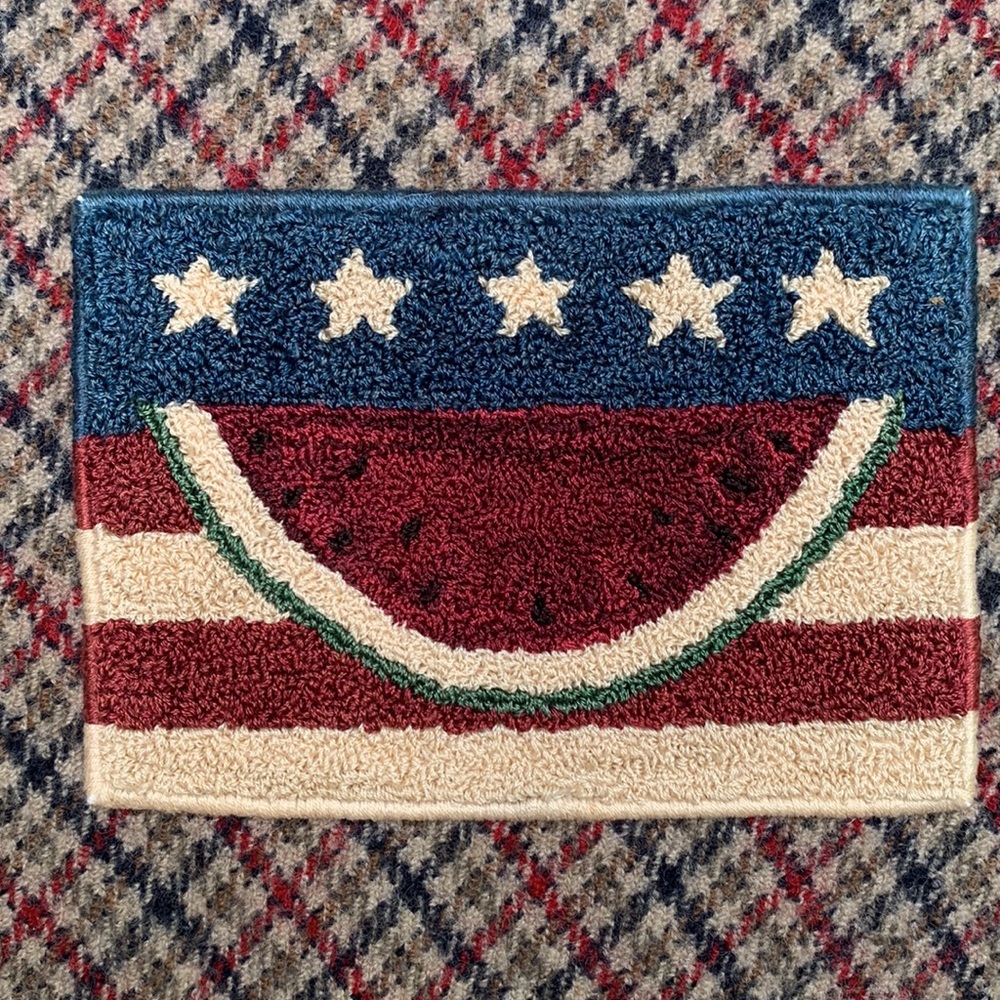 Hand stitched watermelon appliqué seen to soft wool “matting”